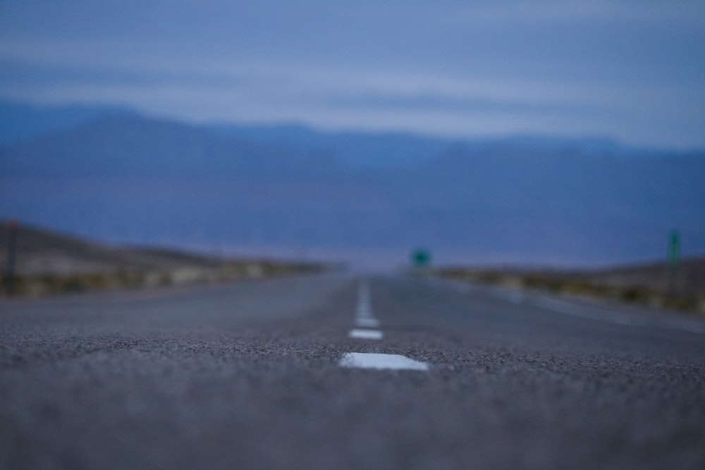 shallow focus photography of asphalt road