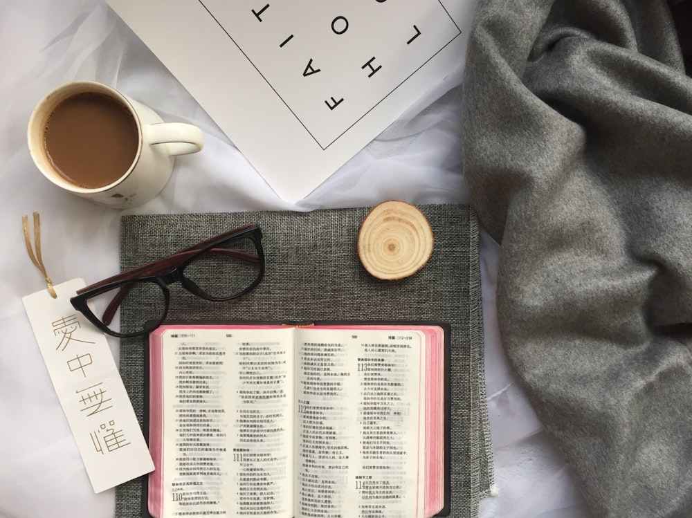 mug of coffee near eyeglasses and coaster