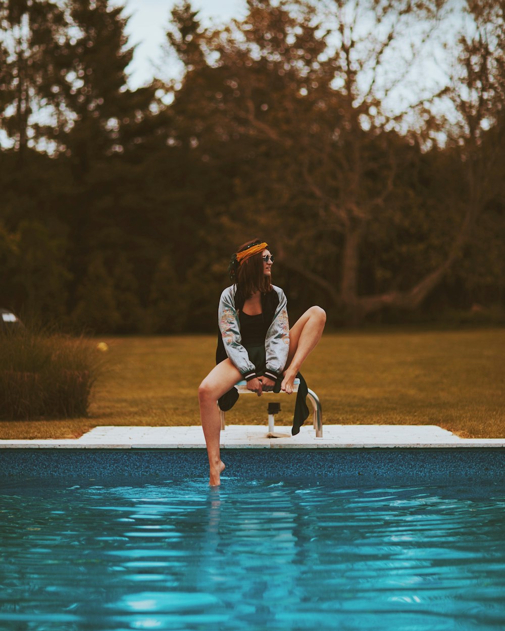 woman sitting beside swimming pool