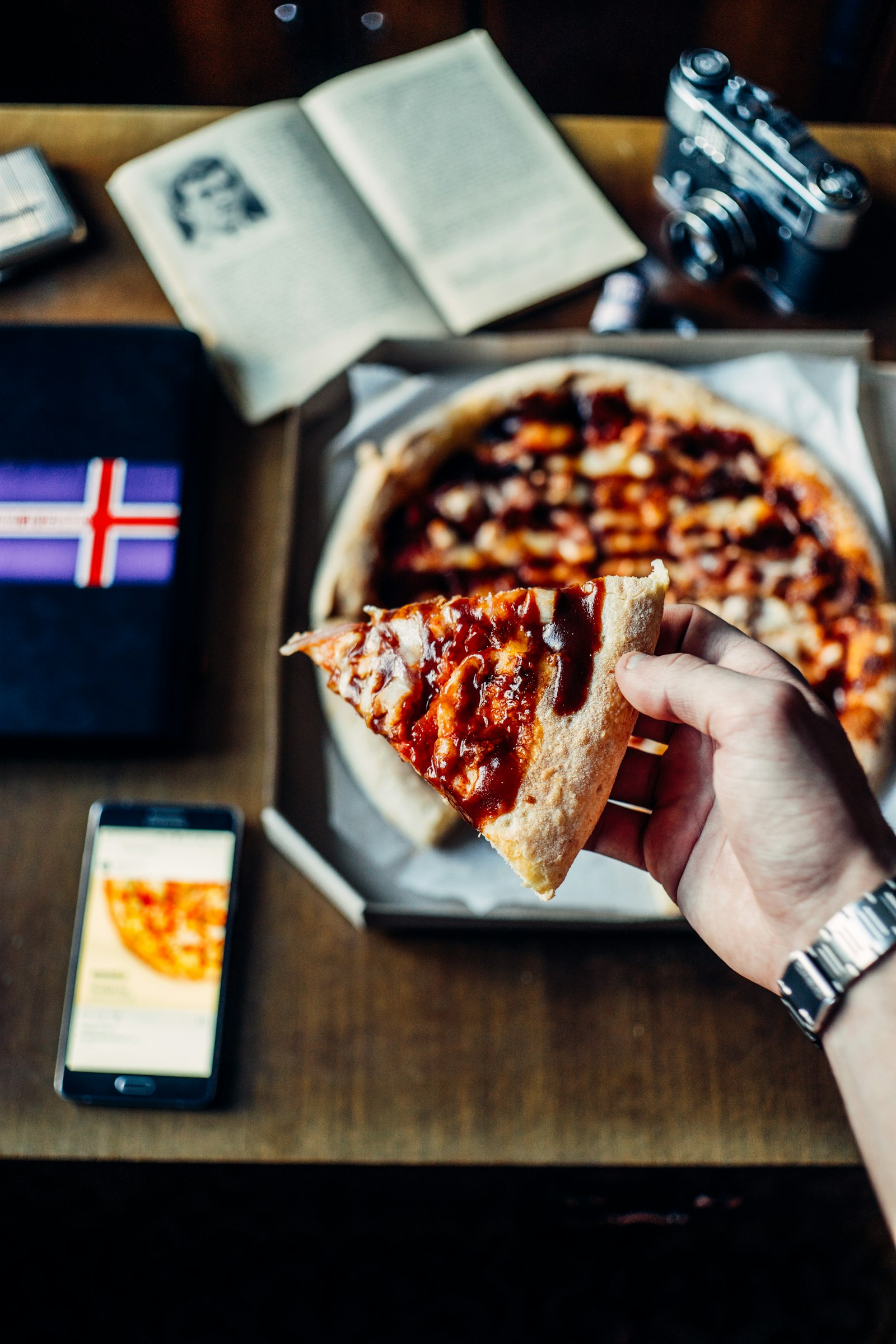 Sony a7 + Sony DT 50mm F1.8 SAM sample photo. Person holding pizza slice photography