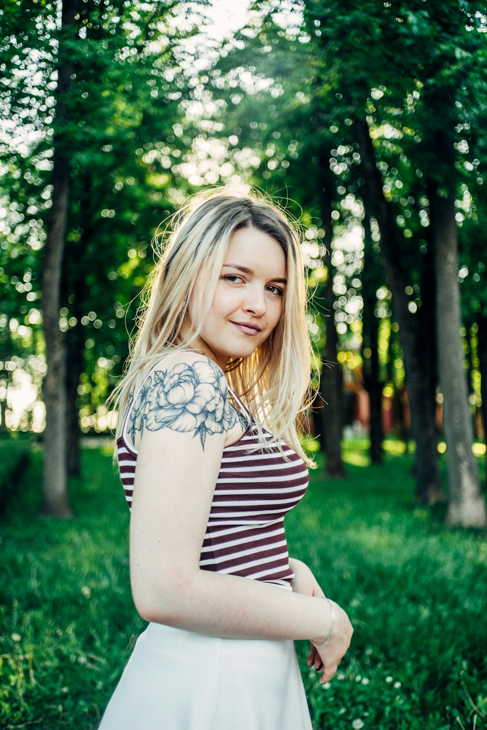 smiling woman standing in a forest during daytime