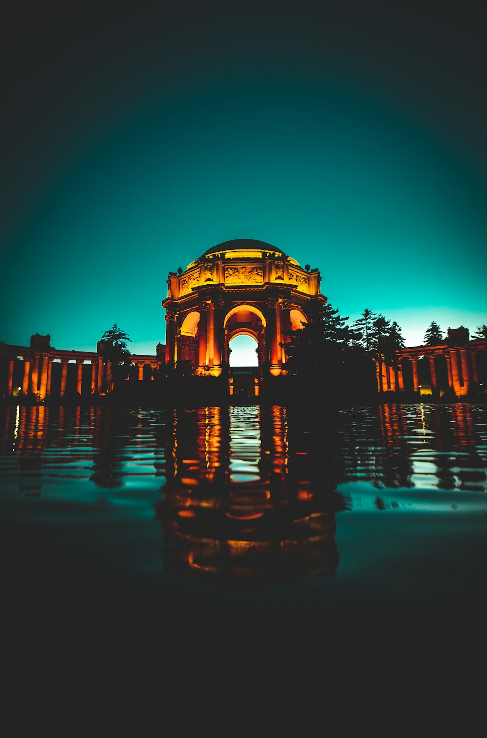 lighted concrete dome building near body of water