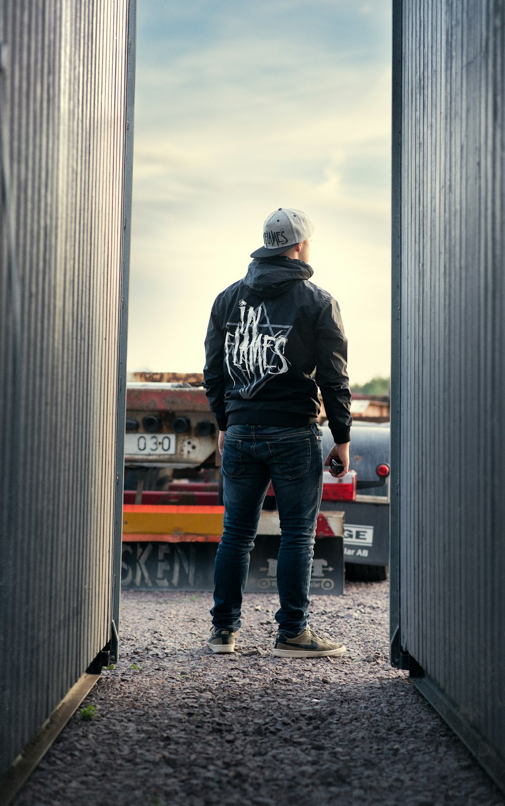 man standing in middle of two corrugated sheets