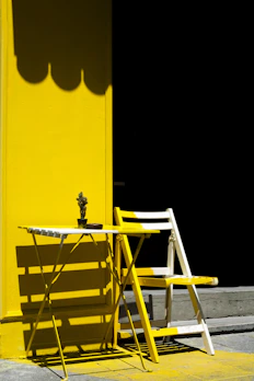 A sunny yellow table with smooth edges on a wooden floor.