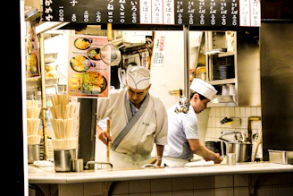 Chef preparing Japanese cuisine in a spotless, high-end kitchen.
