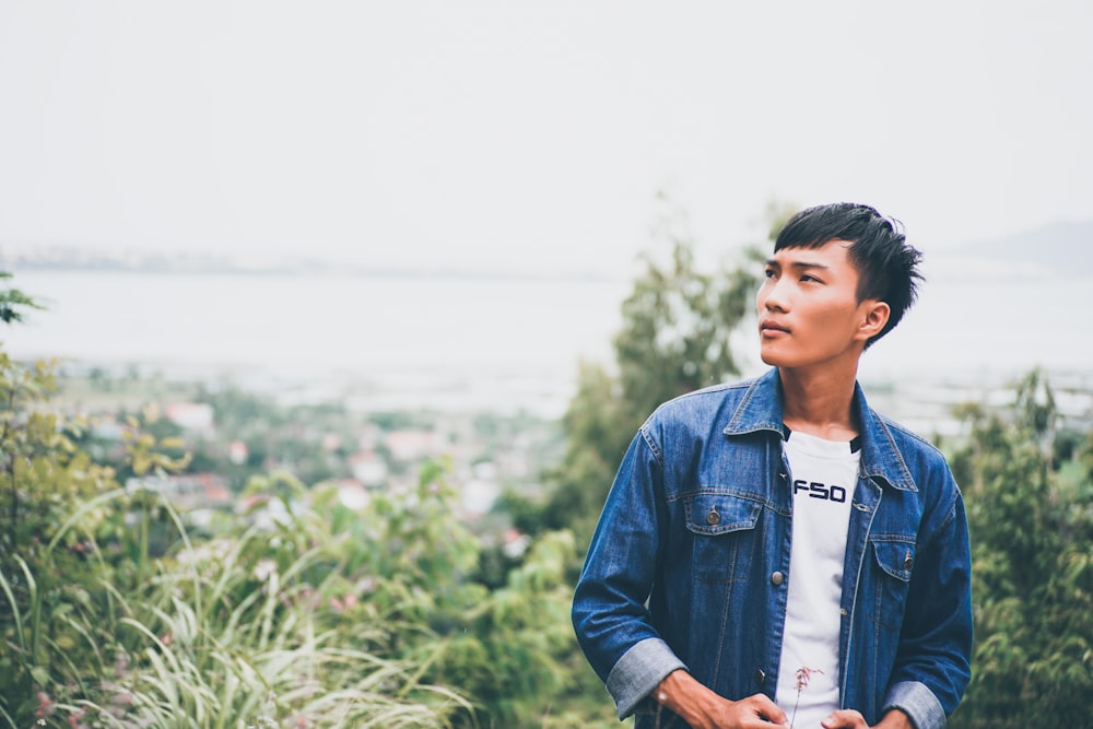 selective focus photography of man standing near trees