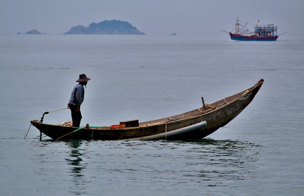 homme équipant un bateau de pêche sur un plan d’eau