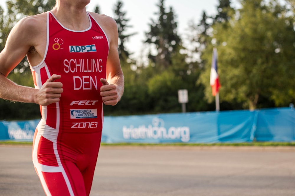 man wearing red suit running on road