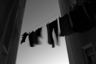 grayscale clothes hanging on cable