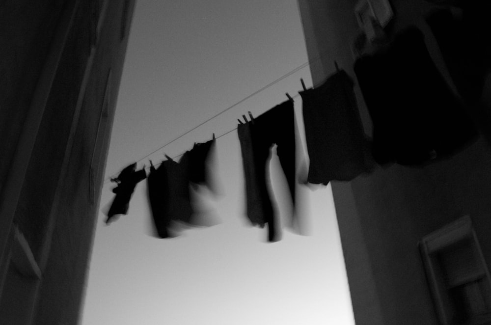 grayscale clothes hanging on cable