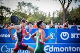 two men running on field with people on side cheering for them