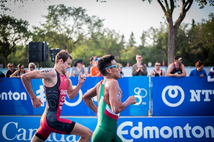 two men running on field with people on side cheering for them