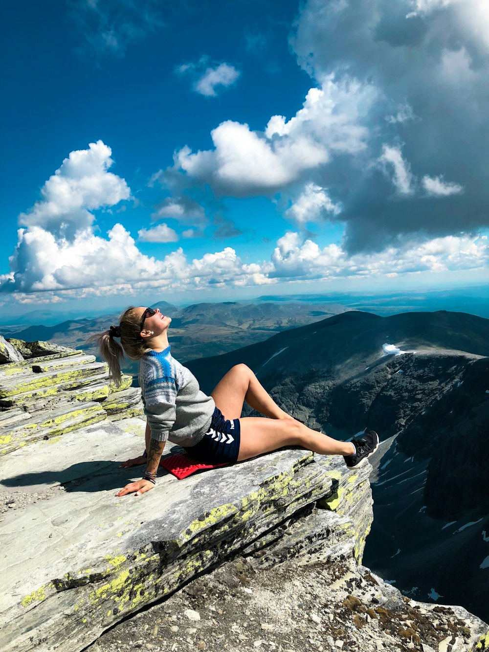 Frau sitzt auf dem Gipfel des Berges