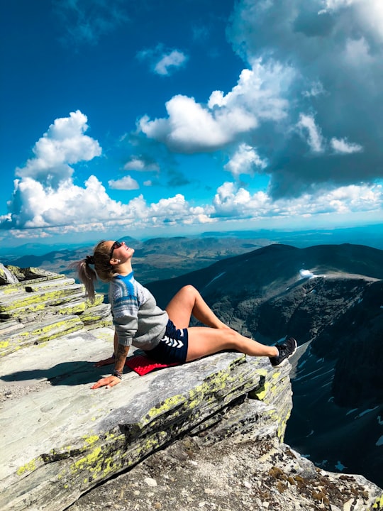 woman sitting on peak of mountain in Rondane National Park Norway