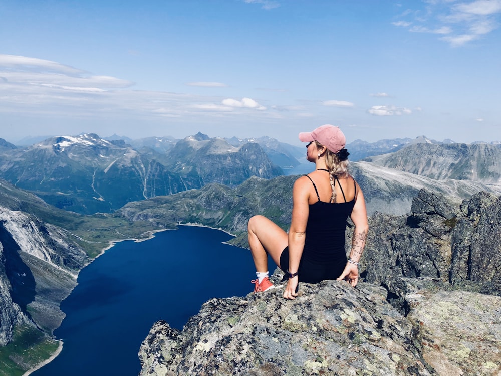 Frau sitzt auf Bergklippe