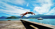 person jumping on body of water at daytime