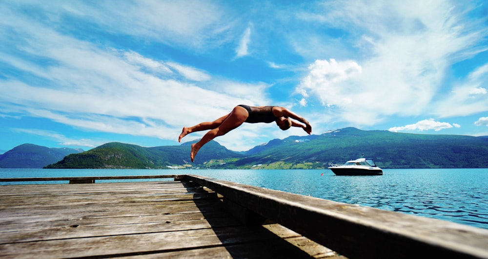 person jumping on body of water at daytime