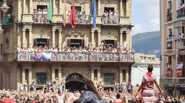 The crowd in red and white beneath the town hall — Pamplona, Spain