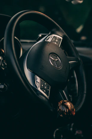 Close-up of a high-end steering wheel with illuminated controls, symbolizing precision and control.