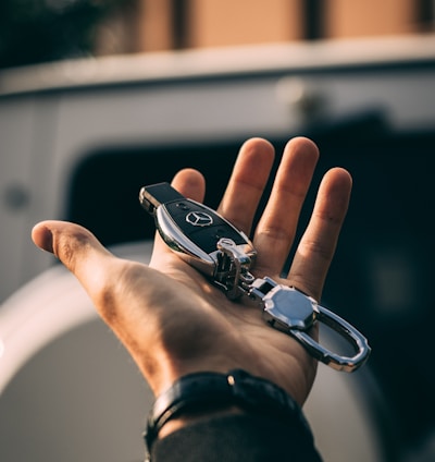 person holding Mercedes-Benz fob