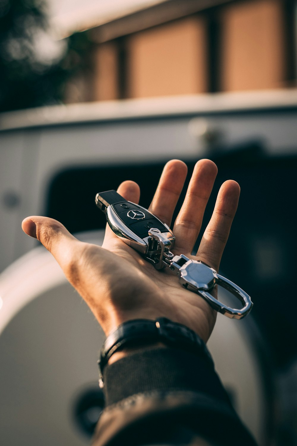 Person mit Mercedes-Benz Schlüsselanhänger