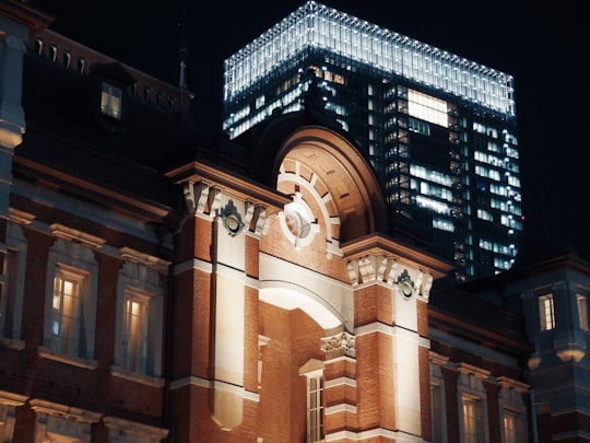 low angle of brown concrete building under dark sky in Marunouchi plaza Japan