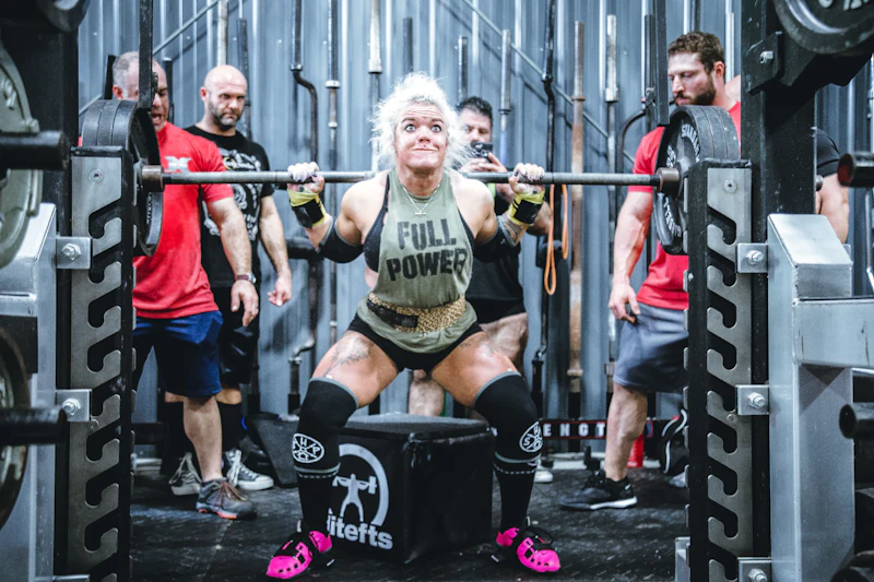 Mature woman in a heavy barbell squat, strength environment