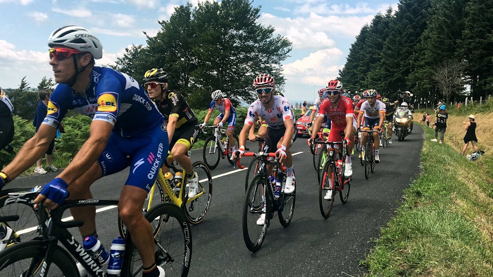 自転車に乗って道を走る人々のグループ