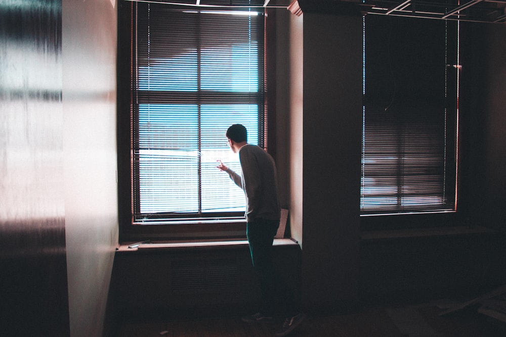 Mann steht in der Nähe des Fensters im Gebäude