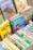 A collection of colorful children's books with illustrated covers, prominently featuring titles by Enid Blyton. The books are neatly arranged in a box, showcasing a variety of themes, including circus, adventure, and fantasy.