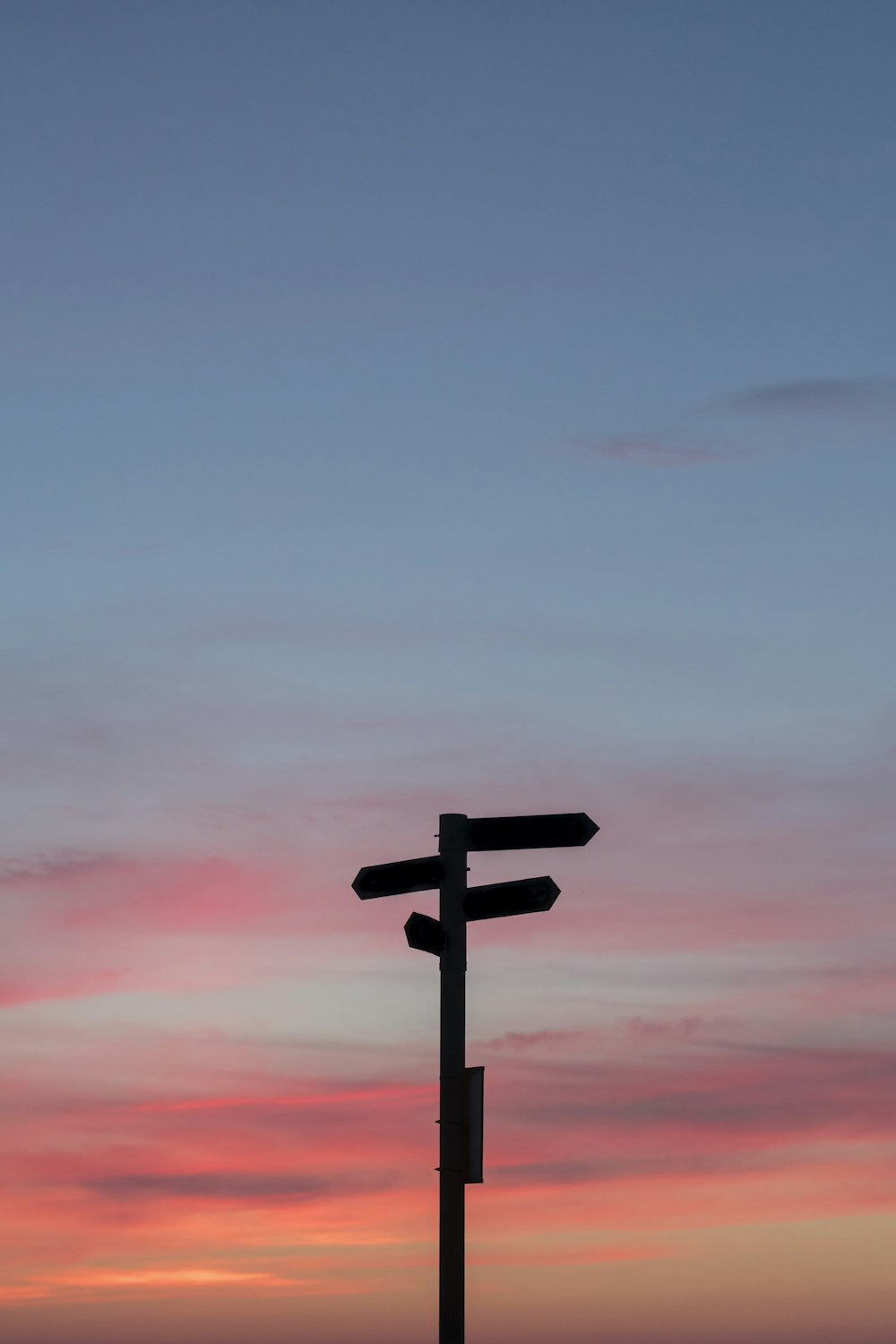 silhouette of a road signage during golden hour  with pink and blue sky