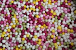 Close-up of colorful beads arranged in traditional patterns on a white cloth.