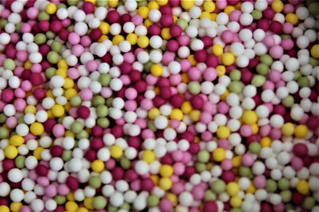 Close-up of colorful beads arranged in traditional patterns on a white cloth.