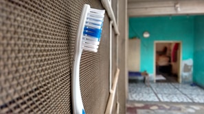 A modern toothbrush with an ergonomic handle and angled bristles resting on a bathroom counter