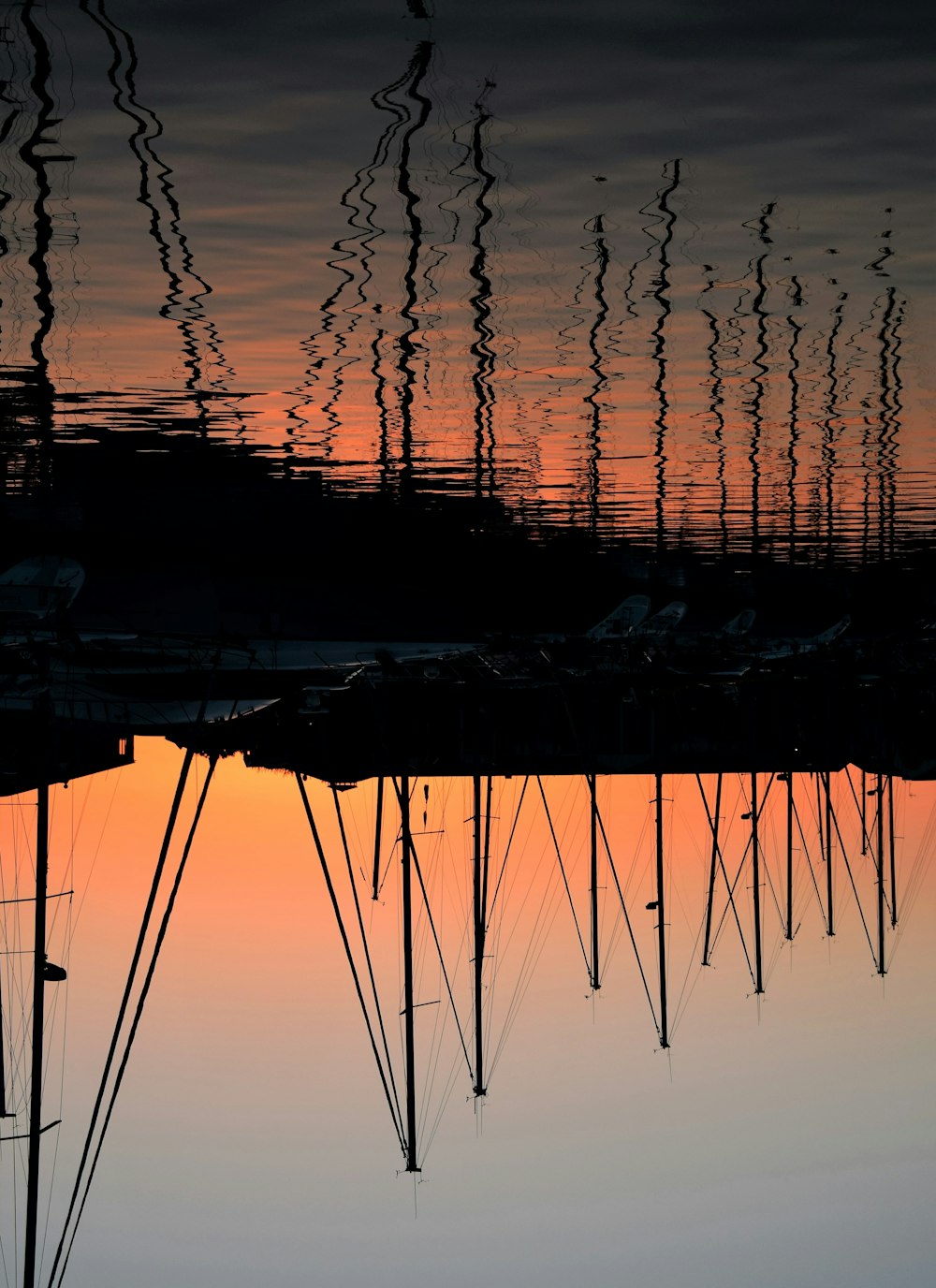 reflective shot of boats on dock