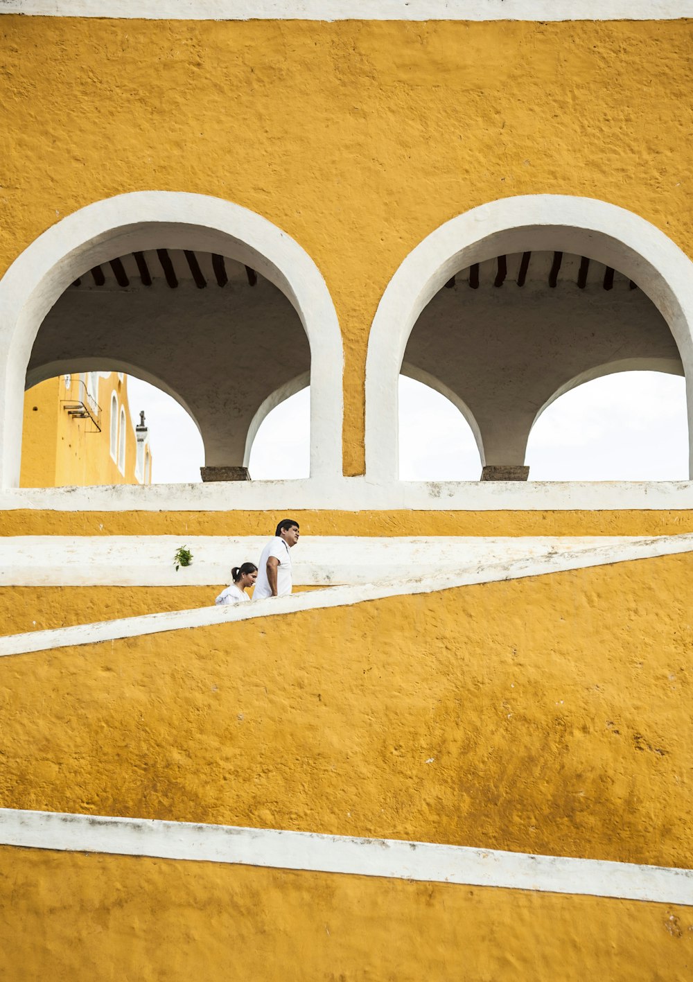 man and woman walking up on yellow stairs