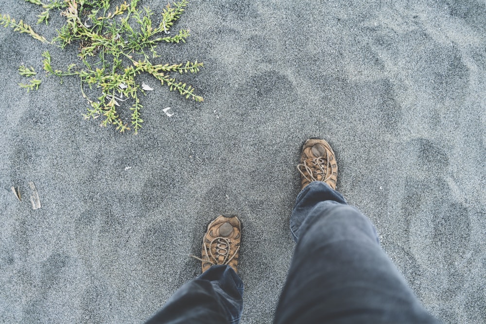 Person, die auf grauem Sand steht