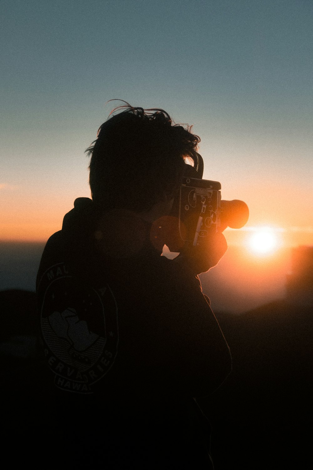 uomo che tiene la macchina fotografica classica durante l'ora d'oro