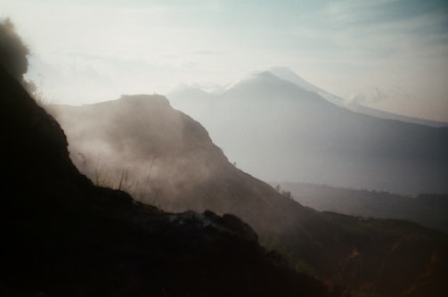 A misty mountain landscape at dawn, with layers fading into the distance.