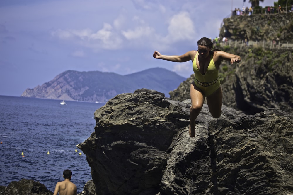 time lapse photography of woman wearing one-piece swimsuit jumping from cliff