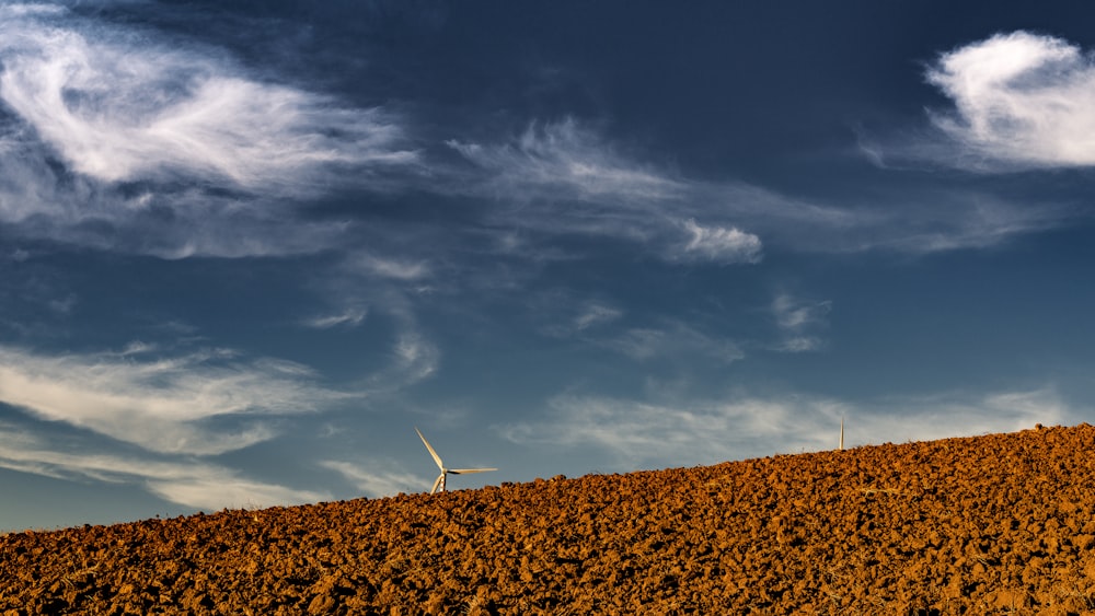 white windmill under cloudy sky