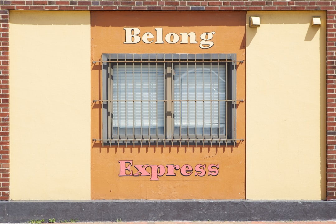 Belong Express facade, Barred windows in Newark NJ with ‘Belong’ written above them.