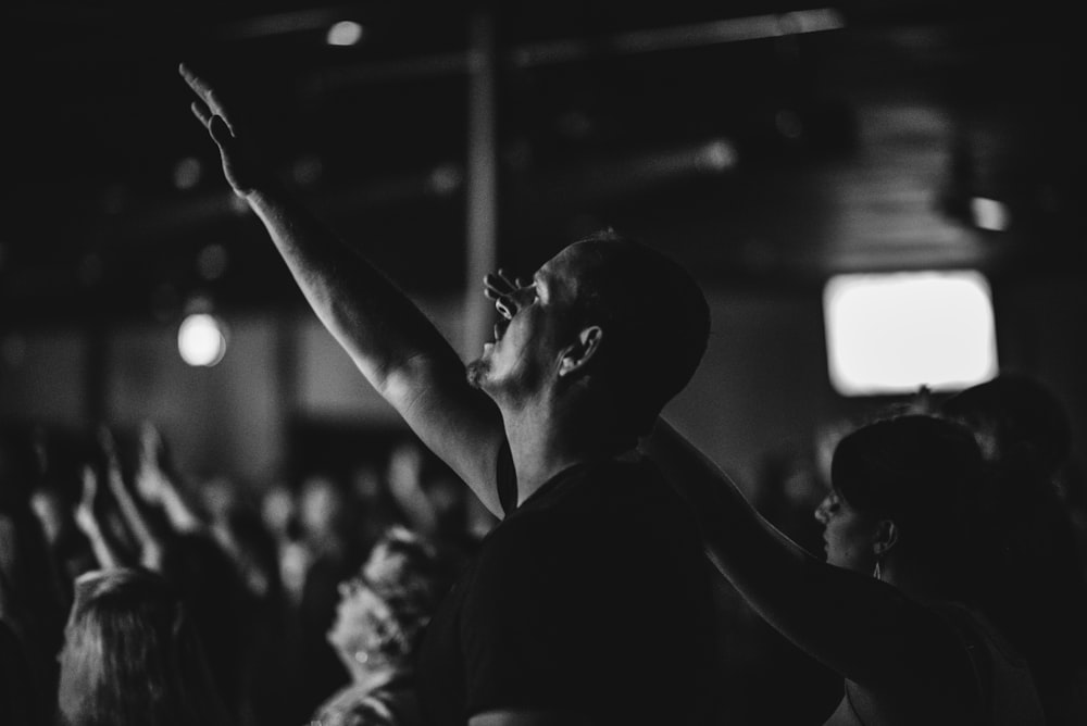 grayscale photo of man in praising gesture