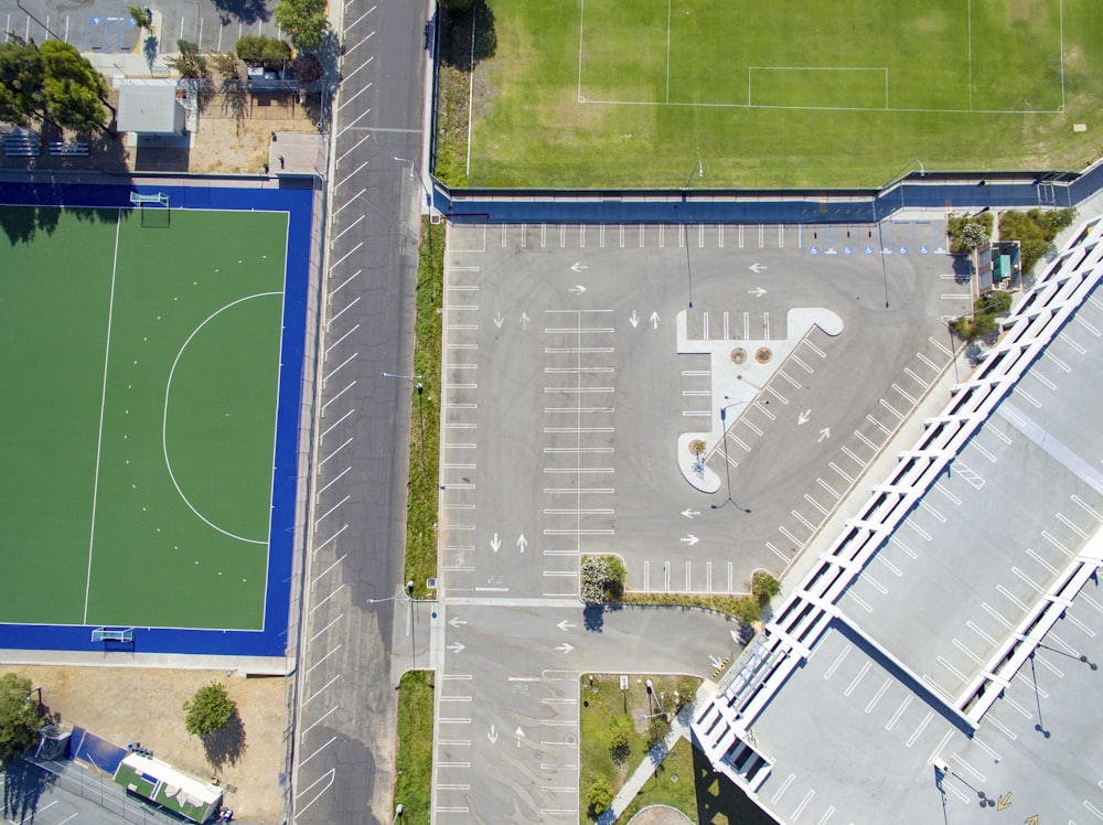 aerial photo of gray concrete pavements near field and tress