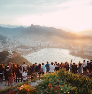 group of people standing facing lake view