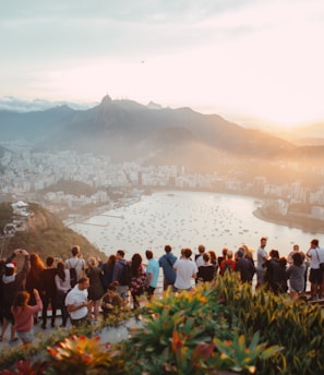 group of people standing facing lake view