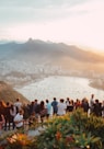 group of people standing facing lake view