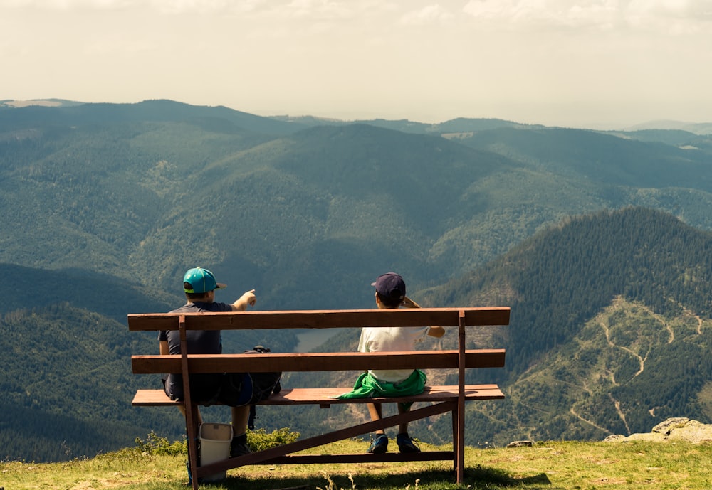 two boys sitting on brown bench