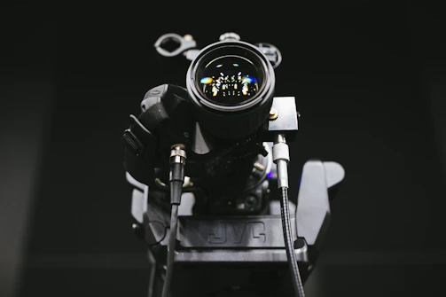 Close-up of film equipment with reflections of the crew visible in the lens glass.