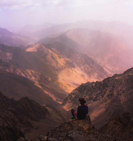 man sitting on mountain edge in Toubkal Morocco